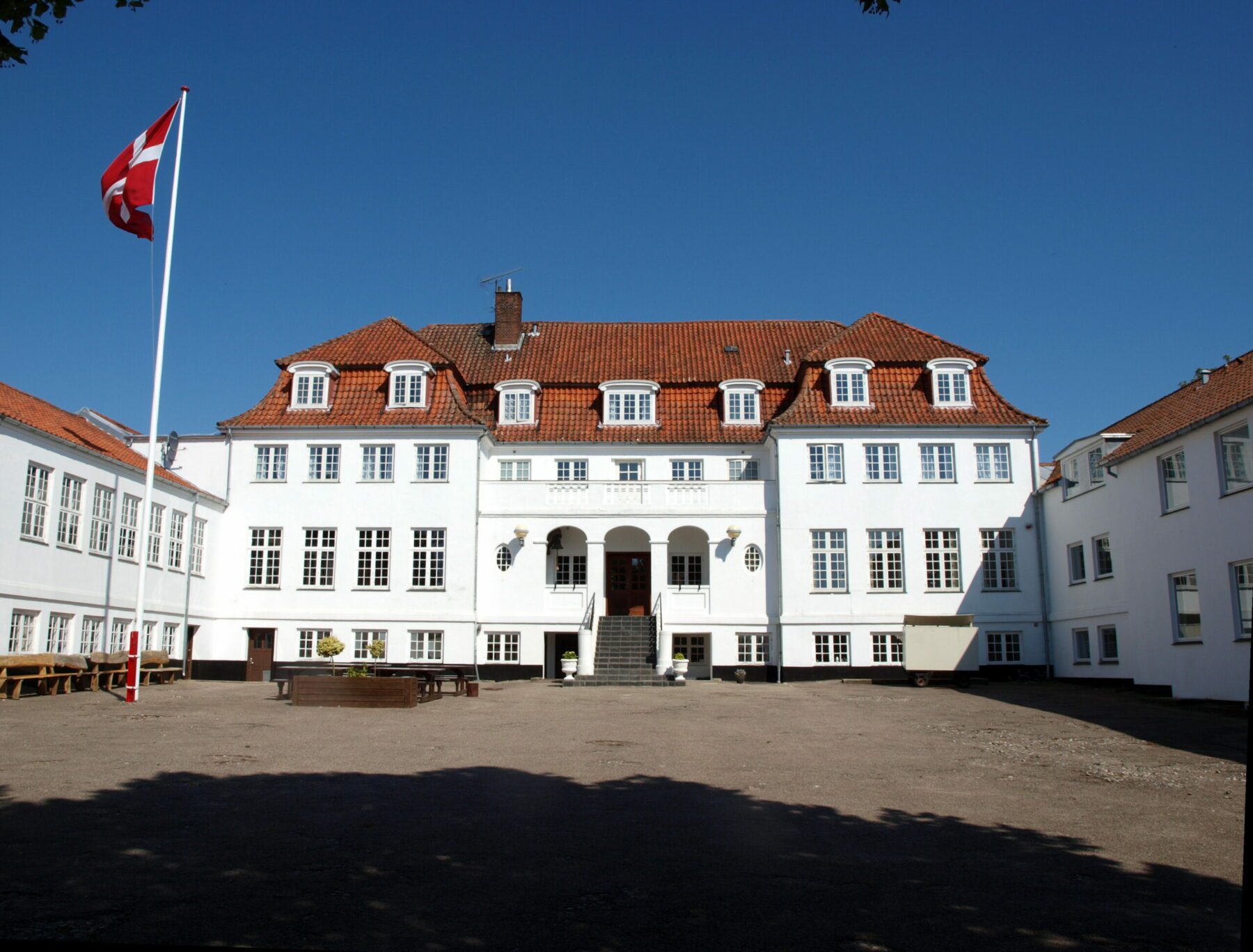 lundby efterskole facade. Stor hvid bygning af efterskolen og dens indgang.