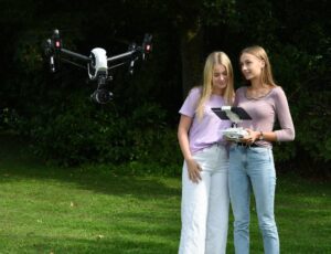 2 kvindelige elever der styre en drone udenfor i naturen på kundby efterskole